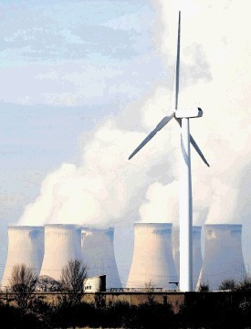 A wind turbine stands alone against the Drax Power Station, the largest coal-fired station in the UK