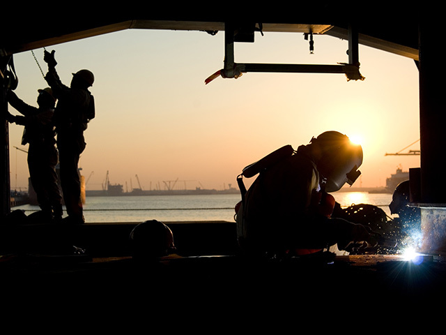 Silhouette of workers at a yard