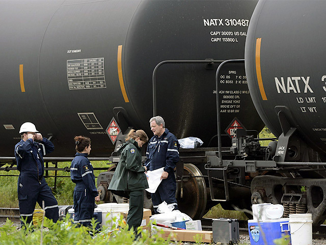 Investigators inspect the oil tankers after the train crash