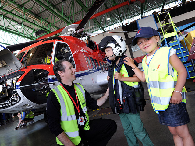 Pilot Will Nahekom shows off flight kit to Kaiden Clark and Ellie Marnoch at the CHC open day in Dyce