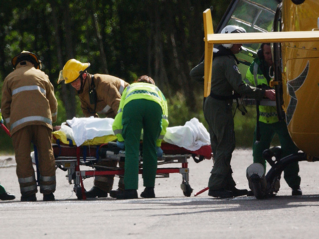 Paramedics and firefighters comfort a victim coming from medevac helicopter