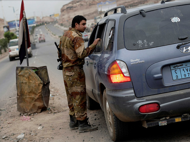 A soldier conducts inquiries at a Yemeni checkpoint. Pic: AP