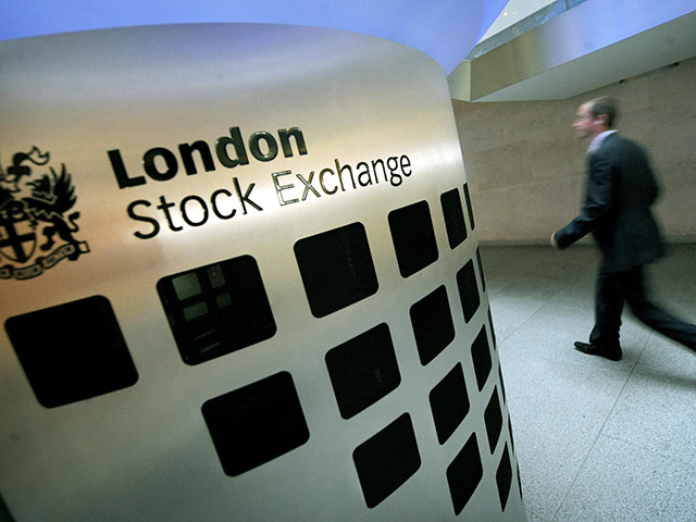 London Stock Exchange logo on wall as man walks past