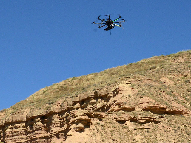 Flying robot (UAV) surveying a cliff