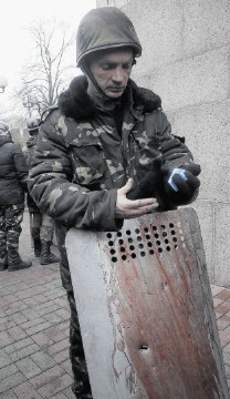 HELL: An activist holds a shield covered with the blood of his comrade killed in clashes with police in Kiev's Independence Square, the epicentre of the country's current unrest