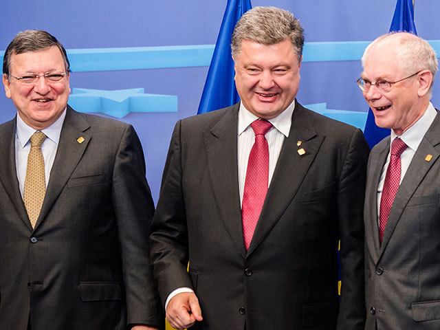 EU Commission President Jose Manuel Barroso, left, and EU Council President Herman Van Rompuy, right, smile as they talk with Ukraine's President Petro Poroshenko during an EU summit in Brussels