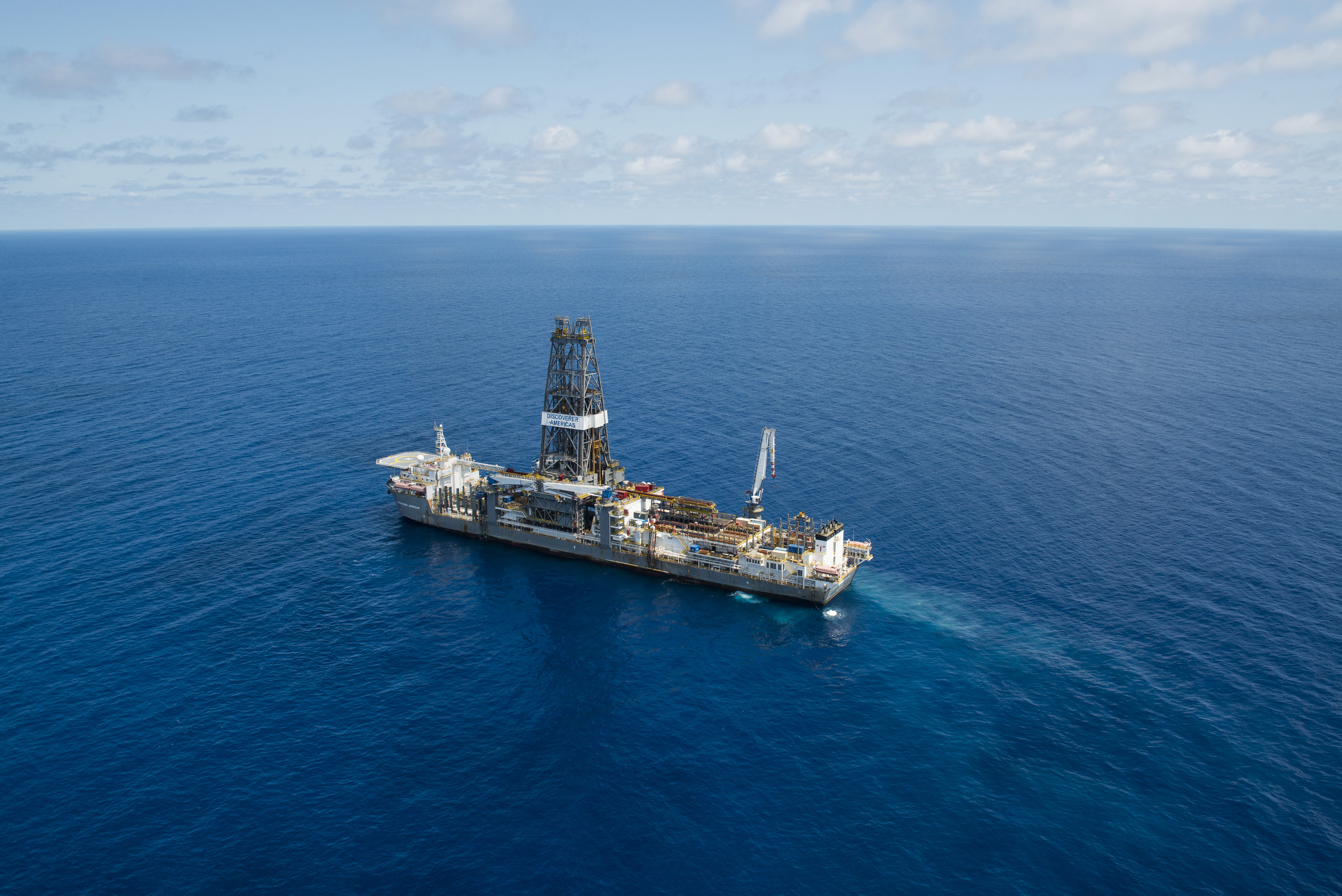 A drillship in blue seas, with a horizon