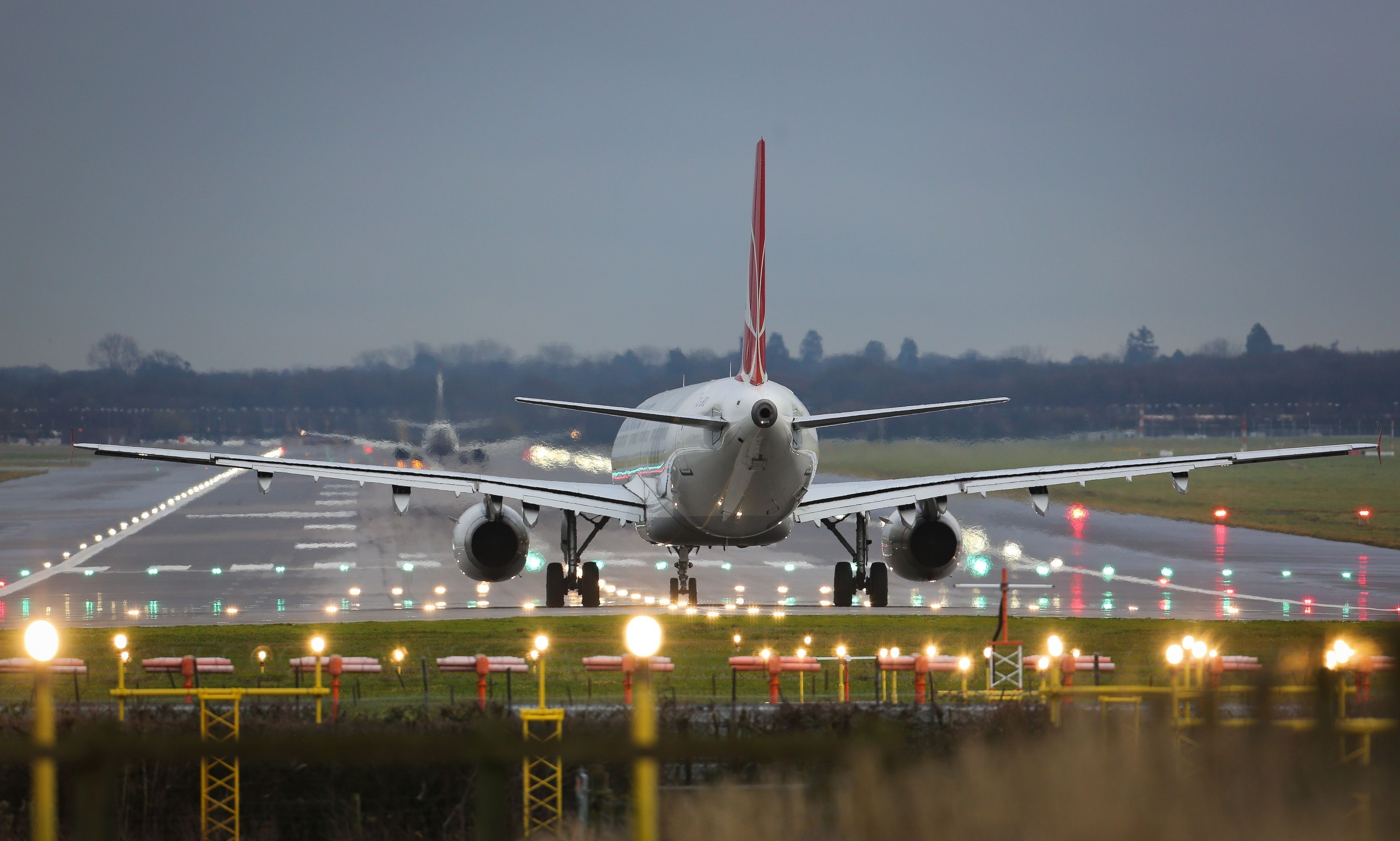 Plane lands at landing strip with lights