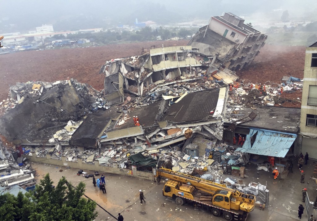 Rescuers search for survivors amongst collapsed buildings after a landslide in Shenzhen, in south China's Guangdong province, Sunday Dec. 20, 2015.  The landslide collapsed and buried buildings at and around an industrial park in the southern Chinese city of Shenzhen on Sunday authorities reported.