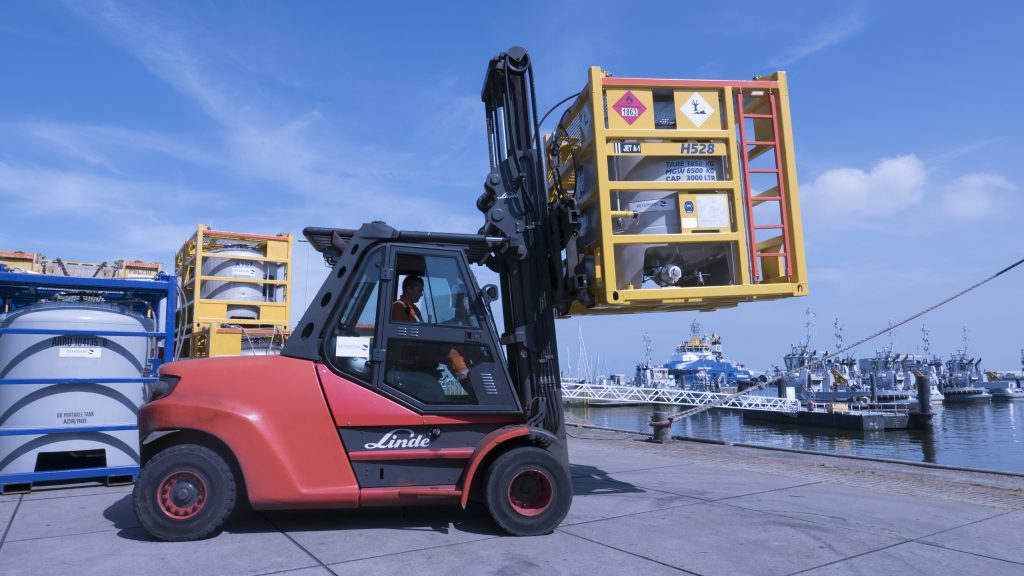 An offshore transport fuel tank being moved in a forklift.