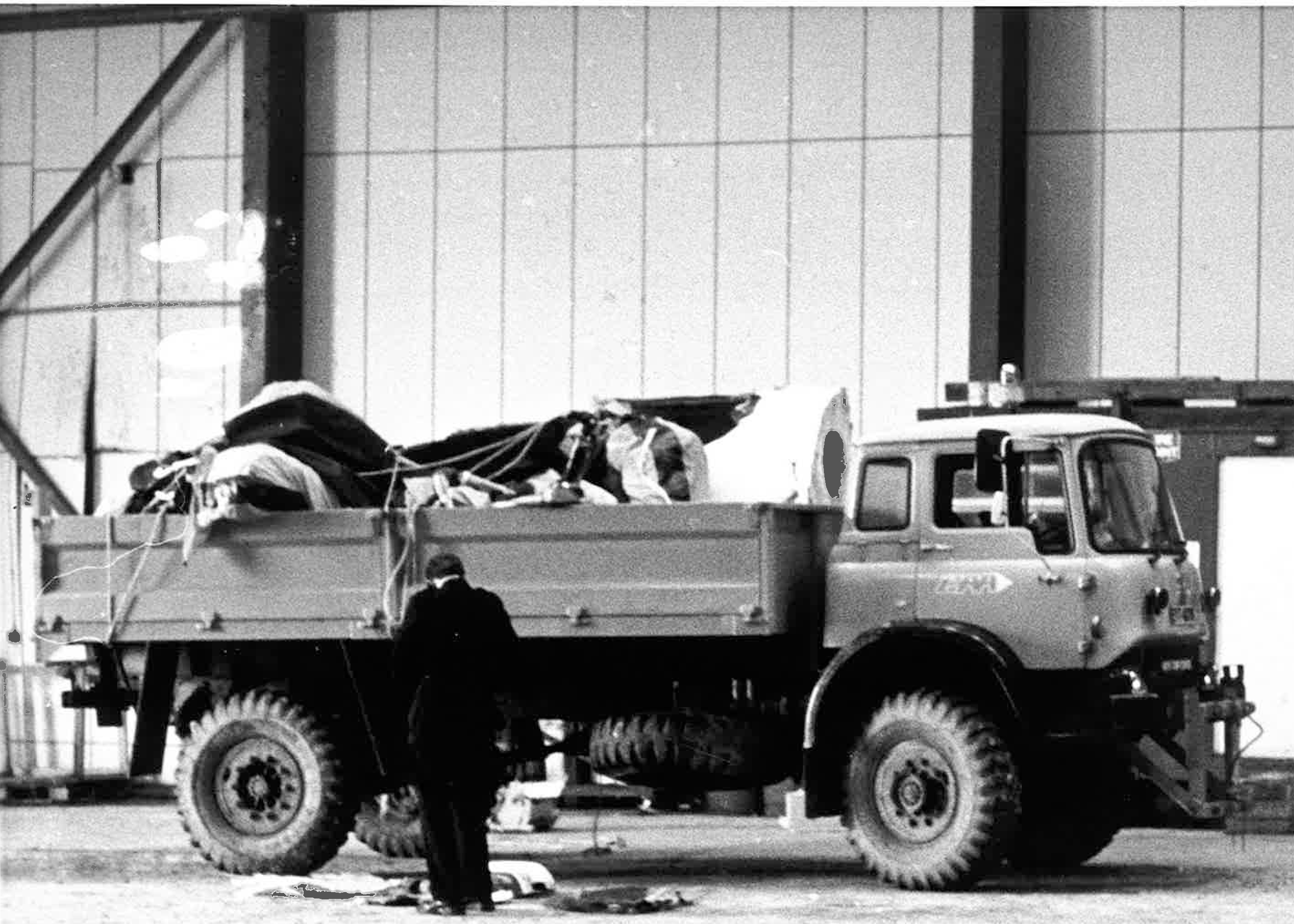 Wreckage of the Chinook helicopter in the back of a lorry is inspected at Sumburgh Airport