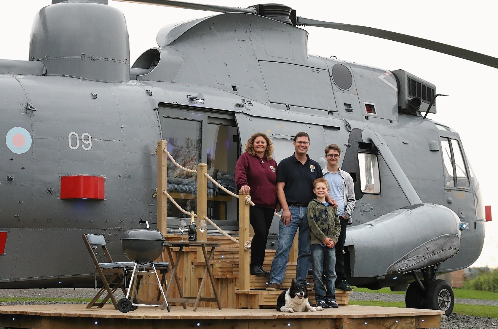 Stirling farmer Martyn Steedman with wife Louise and sons Josh and Harry(front ) on the decking steps of their retired Sea King helicopter. Photo: Andrew Milligan/PA