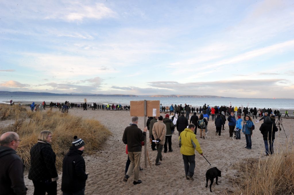 Protest at Nairn against ship to ship oil transfers in the Moray Firth.  A long line of over 500 protesters gather on the beach.