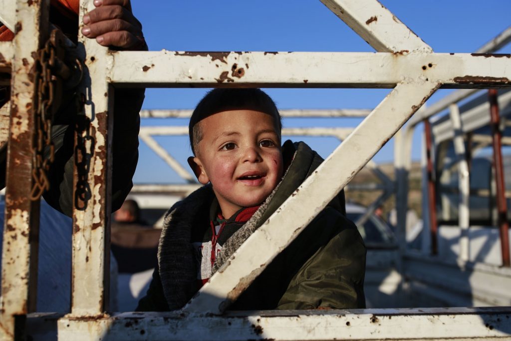 A Syrian child smiles as he is driven away after he and other members of the family crossed into Turkey at the Cilvegozu border gate with Syria, near Hatay, southeastern Turkey, Sunday, Dec, 18, 2016. Several people were able to cross into Turkey after they managed to leave the embattled Syrian city during the ceasefire