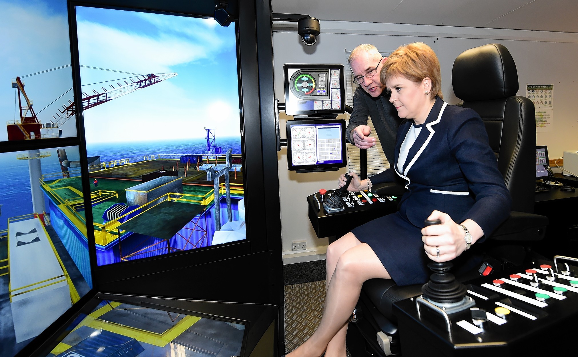 First Minister Nicola Sturgeon at on a crane simulator at Sparrows, with Trevor Dear, Training Centre Supervisor.
