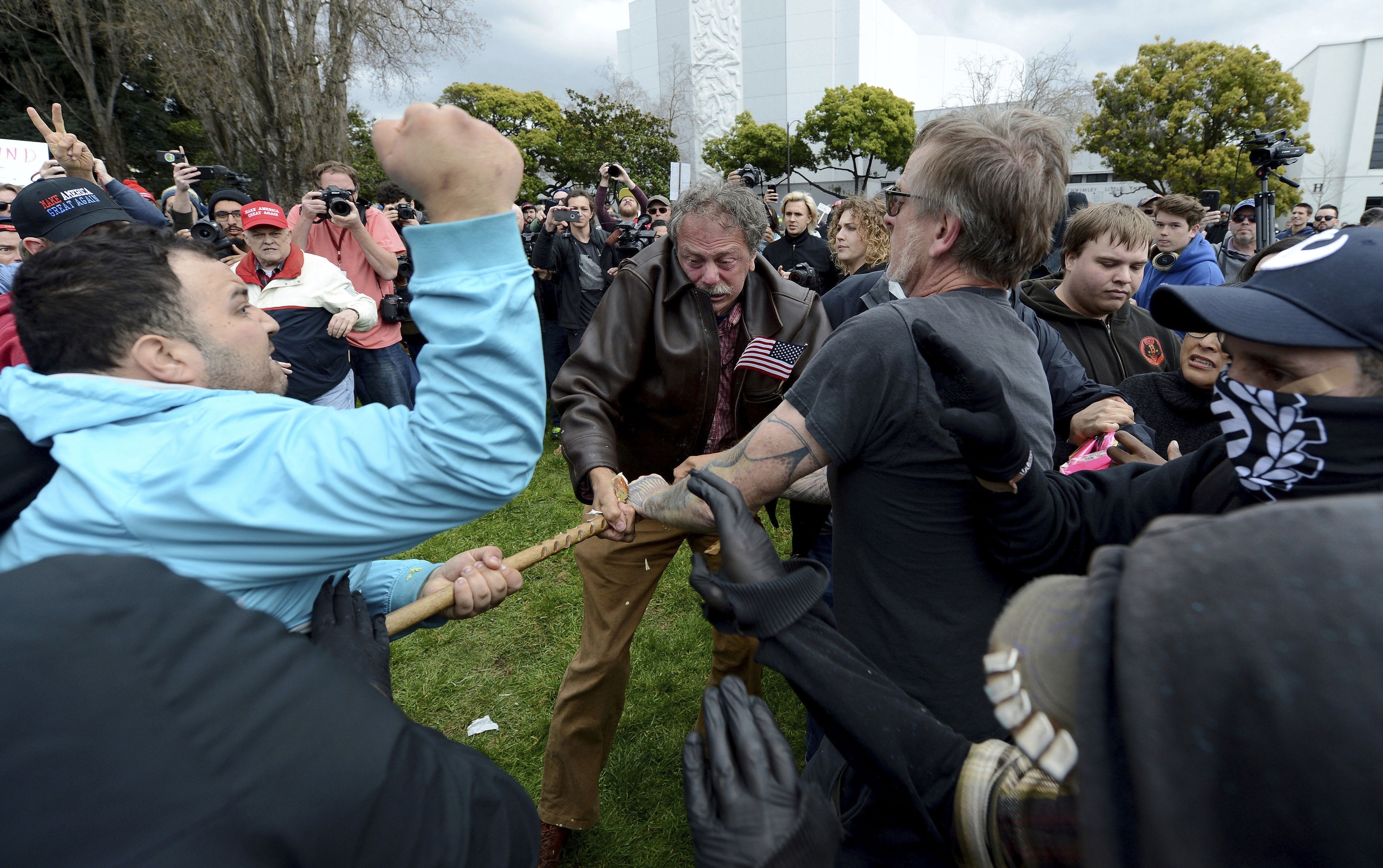 Anti-Trump protesters try to take a large piece of wood away from a Trump supporter at a rally for President Donald Trump at Martin Luther King Jr. Civic Center Park in Berkeley, Calif., Saturday, March 4, 2017. Berkeley Police officers in riot gear arrested at least one person at the rally that attracted hundreds of pro-Trump supporters and opponents at a park less than a mile from the University of California, Berkeley campus.