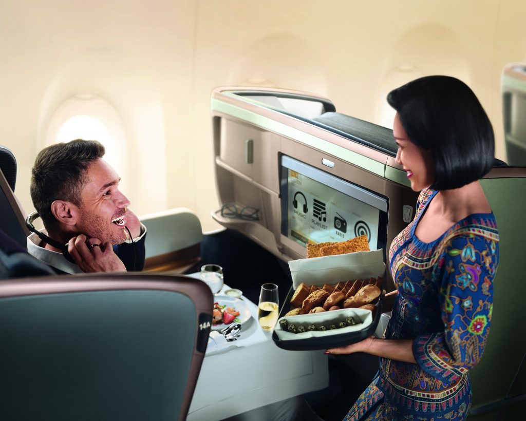 A business class passenger being tended to by an Singapore Airlines stewardess.