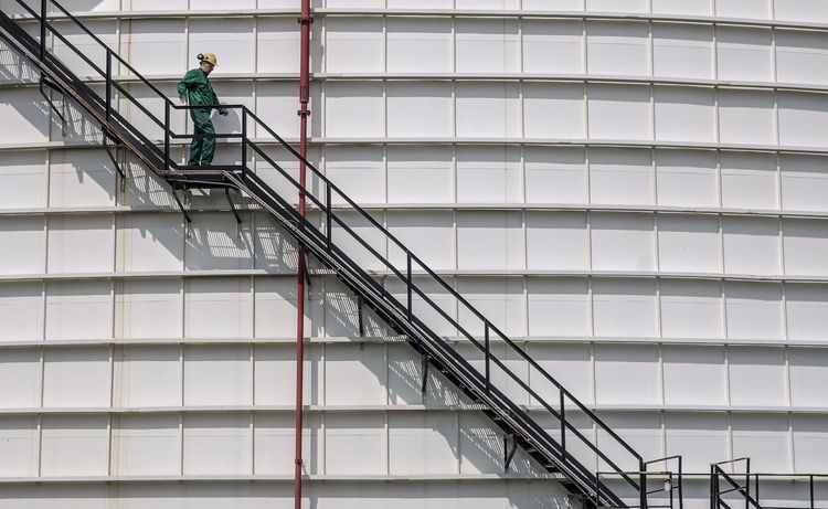 An employee descends the steps outside a 40,000 tonnes crude oil storage tank at the Duna oil refinery, operated by MOL Hungarian Oil & Gas Plc, in Szazhalombatta, Hungary, on Monday, April 10, 2017. MOL Group posted almost $1 Billion profit in 2016. Photographer: Oliver Bunic/Bloomberg