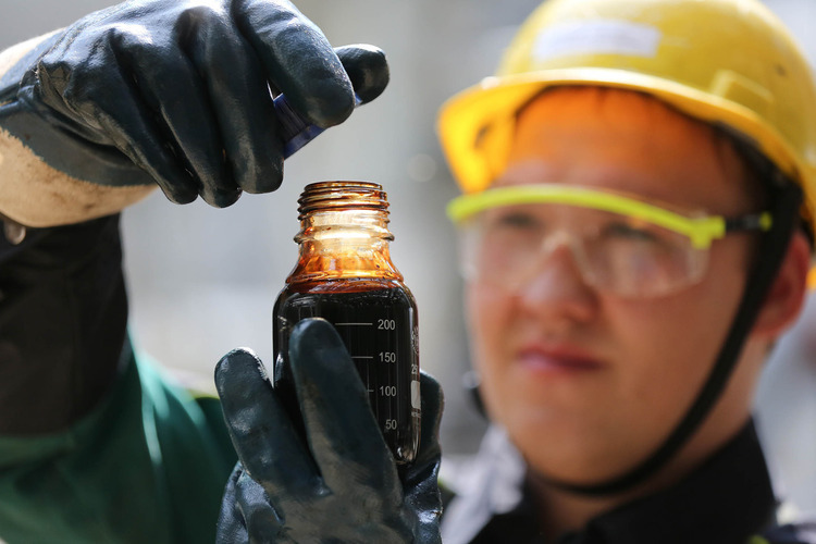 An employee collects a sample of crude oil for laboratory testing at the "TANECO" refining and petrochemical plant, operated by Tatneft OAO, in Nizhenekamsk, Russia. Photographer: Andrey Rudakov/Bloomberg