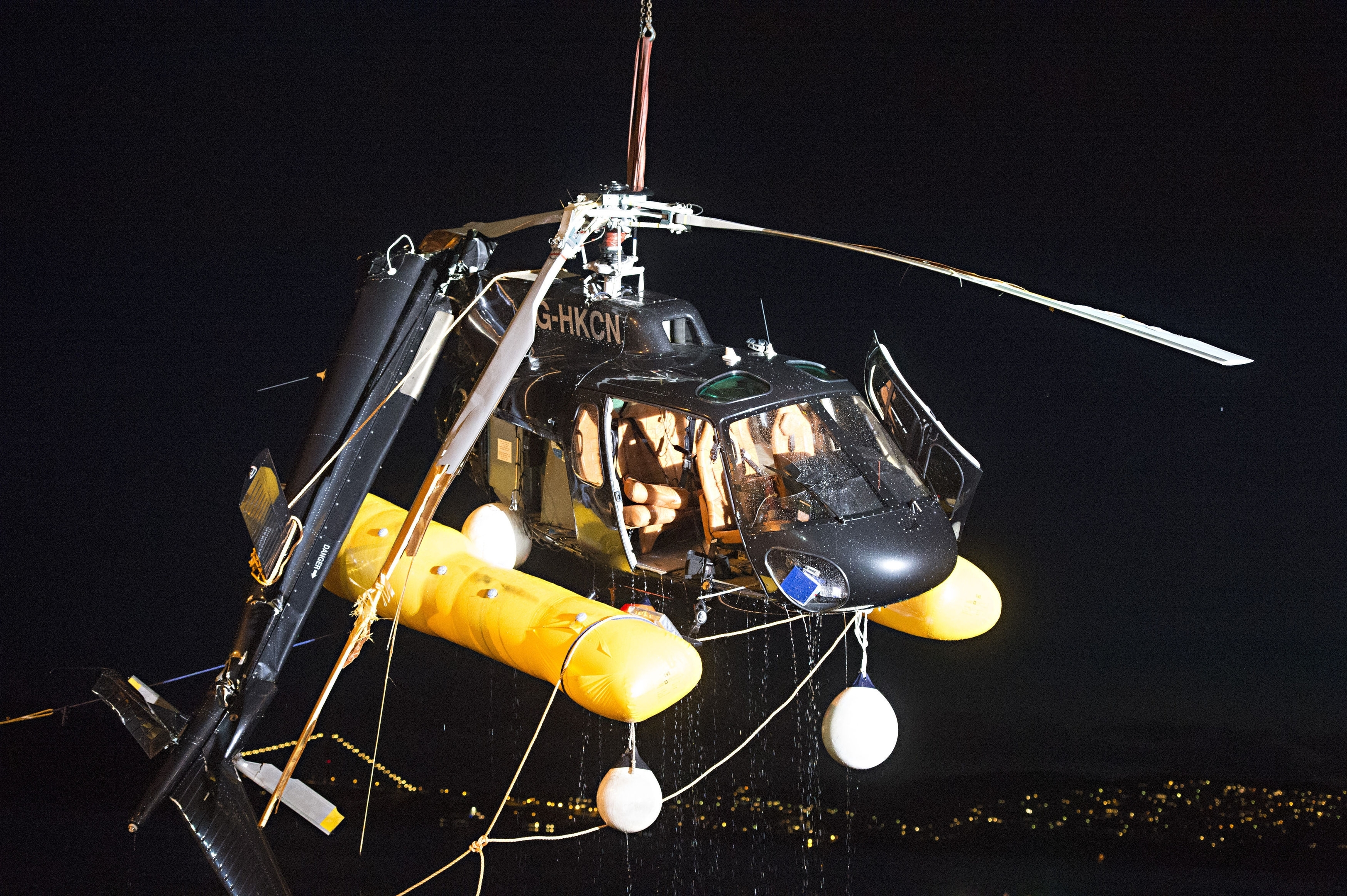 A helicopter which crashed into the sea near Bergen harbour, western Norway, is seen being lifted out from the water in the early hours of Thursday May 11, 2017.