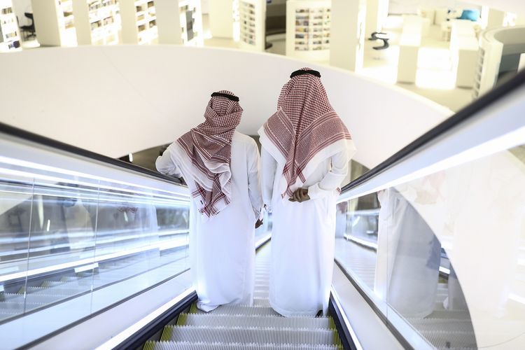 Attendees stand on an escalator as they move through the interior of the King Abdulaziz Center for World Culture during a tour of the project in Dhahran, Saudi Arabia, on Friday, Nov. 25, 2016. When completed, the project designed for the Saudi Arabian Oil Co. (Aramco) will contain diverse cultural facilities, including an auditorium, cinema, library, exhibition hall, museum and archive.