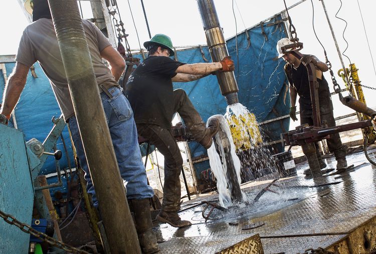 Workers connect drill bits and drill collars, used to extract natural petroleum, on Endeavor Energy Resources LP's Big Dog Drilling Rig 22 in the Permian basin outside of Midland, Texas, U.S. Photographer: Brittany Sowacke/Bloomberg