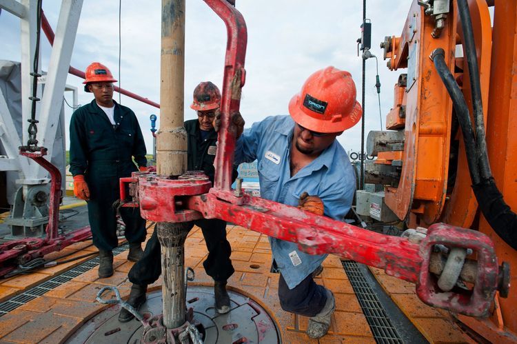 Floor hands David Vannapha, left, Mario Ramos, center, and Jose Garza make a pipe connection on the drill string on the Orion Perseus drilling rig near Encinal in Webb County, Texas, U.S. Photographer: Eddie Seal/Bloomberg