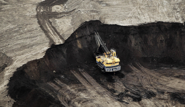 A machine works at the Suncor Energy Inc. mine in this aerial photograph taken above the Athabasca Oil Sands near Fort McMurray, Alberta. Photographer: Ben Nelms/Bloomberg