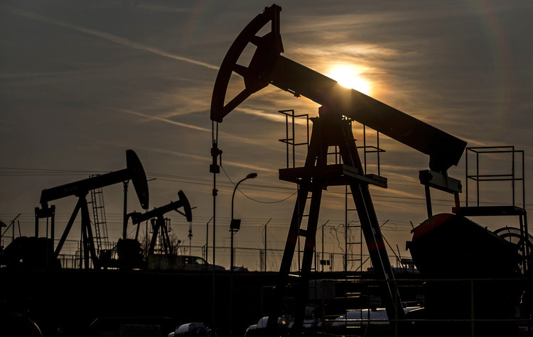 The sun sets beyond oil pumping units, also known as nodding donkeys or pump jacks, at an oil plant operated by MND AS in Uhrice, Czech Republic. Photographer: Martin Divisek/Bloomberg