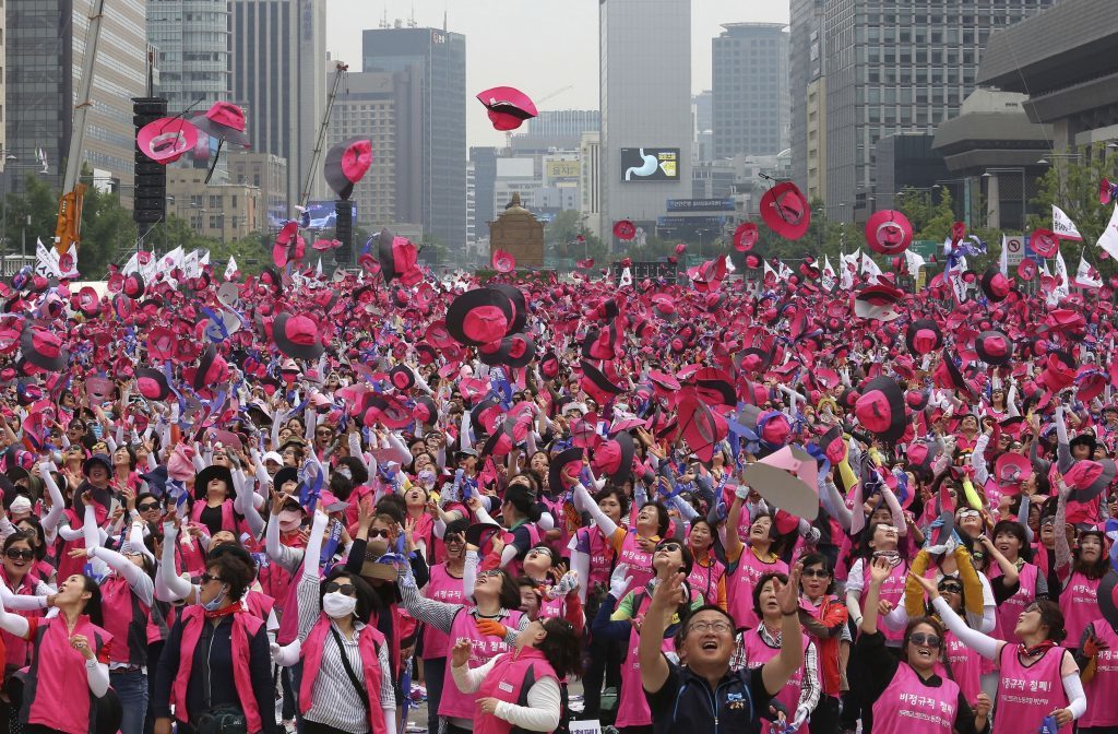 Members of the Korean Confederation of Trade Union toss their hats into the air during a rally against government's labor policy in Seoul, South Korea, Friday, June 30, 2017. Thousands of workers rallied to demand better working conditions and urge companies to stop using temporary employees. (AP Photo/Ahn Young-joon)