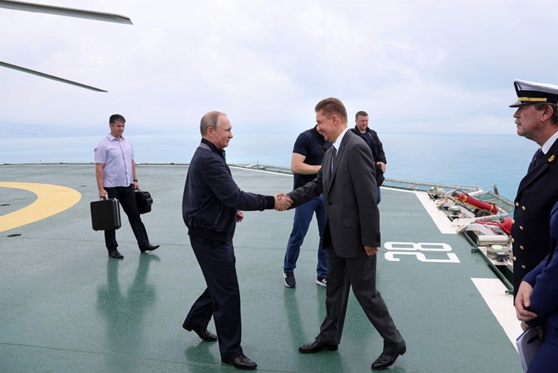 President Vladimir Putin shakes hands with Gazprom's Alexy Miller
