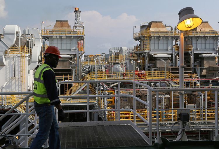 An employee walks along an upper level walkway aboard the Agbami floating oil production, storage and offloading vessel (FPSO), operated by Chevron Corp., in the Agbami deepwater oilfield in the Niger Delta, Nigeria. Photographer: George Osodi/Bloomberg