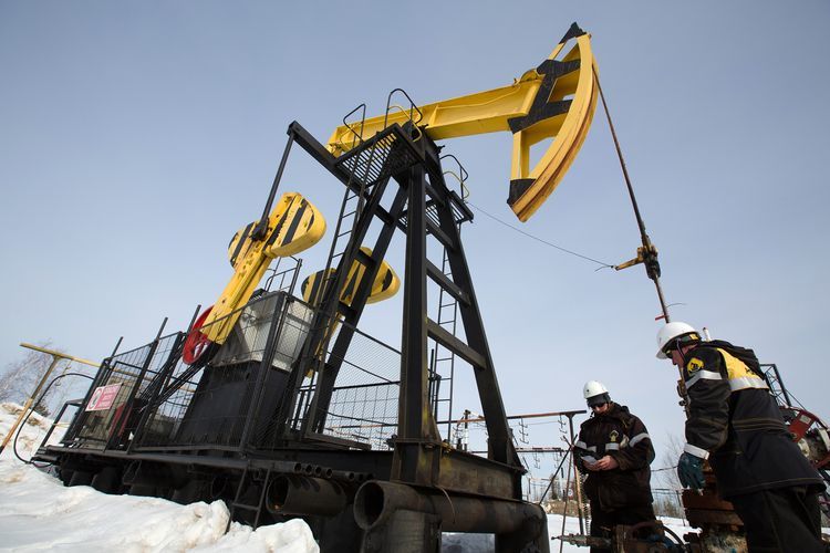 Workers inspect an oil pumping jack, also known as a 'nodding donkey' at a pumping site, operated by Rosneft PJSC, in the Samotlor oilfield near Nizhnevartovsk, Russia, on Wednesday, March 22, 2017. Photographer: Andrey Rudakov/Bloomberg