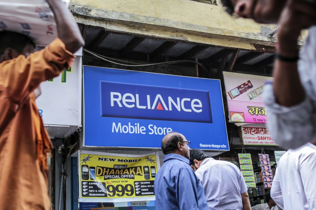 Pedestrians walk past a Reliance Communications Ltd. Mobile Store in Mumbai, India, on Saturday, Feb. 28, 2015. The government auction of telecom wireless spectrum starting March 4 is expected to raise as much as $15.6 billion from service providers including those controlled by billionaires Kumar Mangalam Birla, Sunil Mittal and Anil Ambani, according to ICRA Ltd. Photographer: Dhiraj Singh/Bloomberg