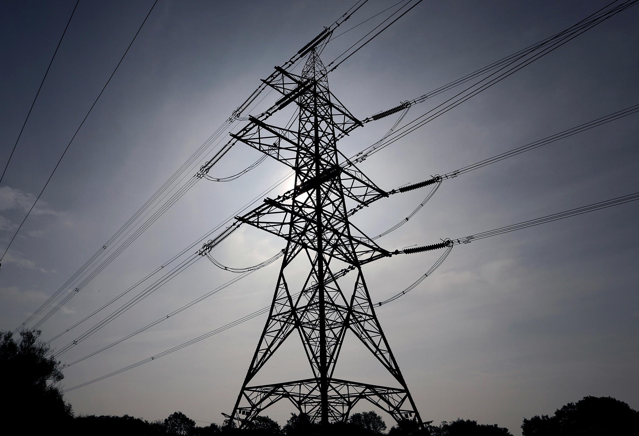 Power transmission lines run from an electricity pylon in Braintree, U.K., on Wedenesday, Sept. 25, 2013. Britain's business lobby groups said that Labour leader Ed Miliband opposition's proposal to break up the "Big Six" utilities and cap power prices threatens the investment needed to avoid blackouts by the end of the decade. Photographer: Chris Ratcliffe/Bloomberg