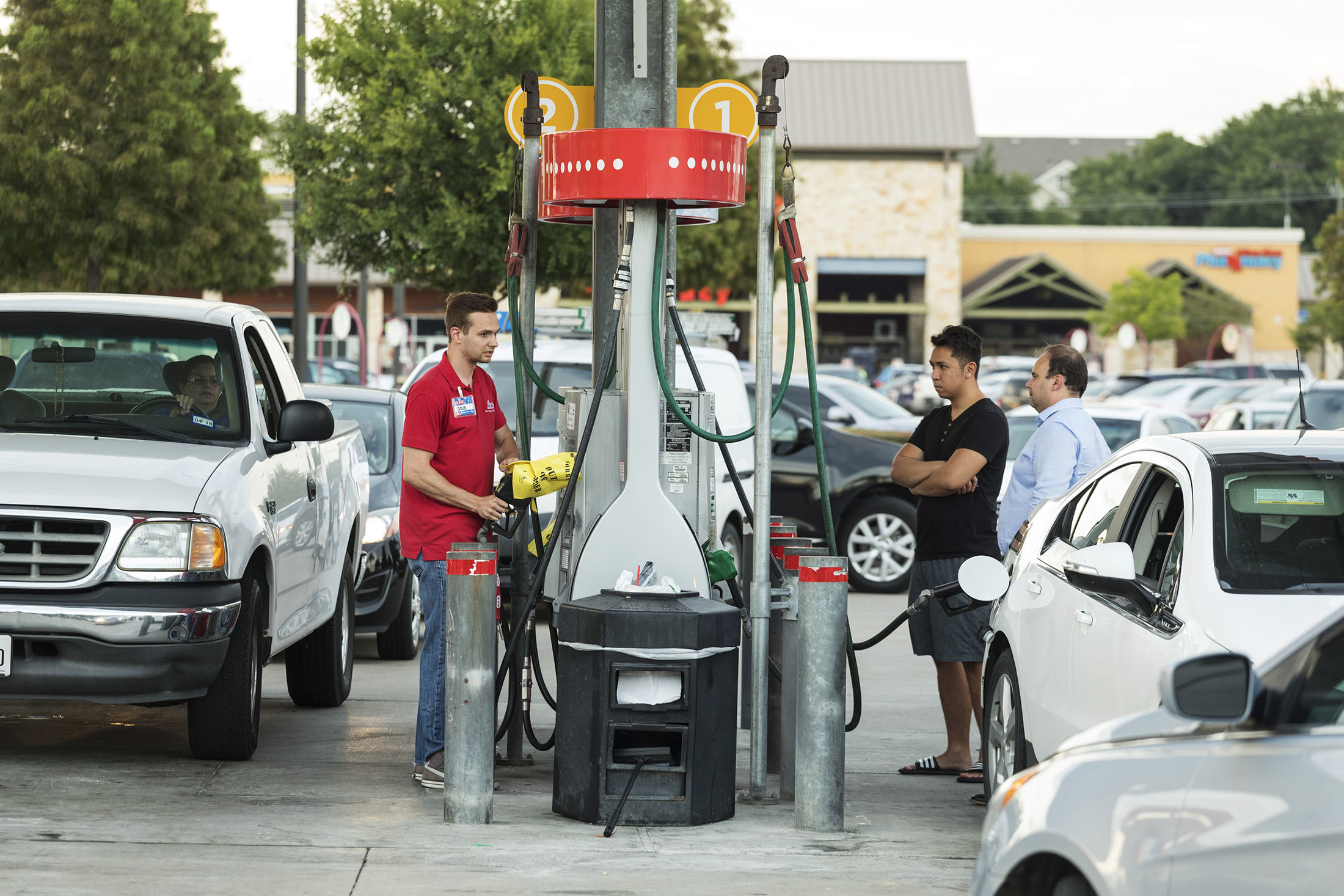 An employee, second left, informs customers of fuel shortage at an HEB Fuel gas station in Houston, Texas, U.S., on Thursday, Aug. 24, 2017. Hurricane Harvey, set to make landfall on the center of the Texas coast late Friday, is expected to hit a refinery-rich stretch of the Gulf Coast and U.S. drivers could soon see the impact at the gas pump. Photographer: F. Carter Smith/Bloomberg