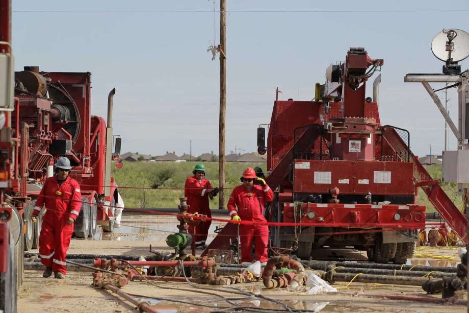 After heavy overnight rains, Halliburton employees look over a Sandcastle at a fracking site operated by Dallas oil company RSP Permian last month in Midland.