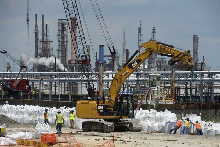 Workers build a wall of sandbags along the damaged levee near the Valero Port Arthur refinery in preparation for Hurricane Harvey on Thursday. Photo taken Thursday 8/24/17 Ryan Pelham/The Enterprise