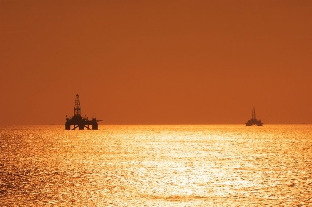 Two offshore oil rigs during sunset in Caspian sea.