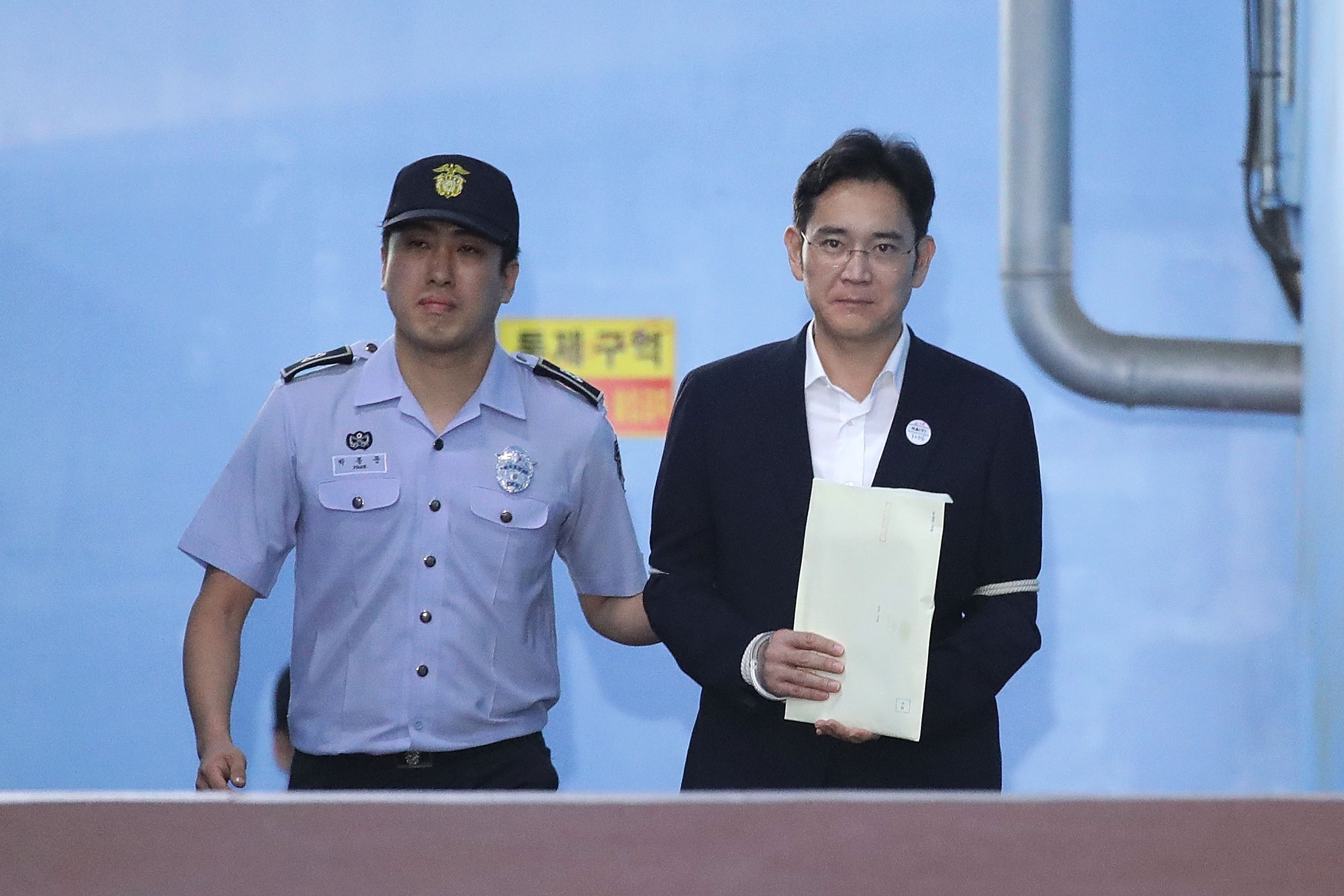 SEOUL, SOUTH KOREA - AUGUST 25:  Lee Jae-yong, vice chairman of Samsung Electronics Co., leave after his verdict trial at the Seoul Central District Court on August 25, 2017 in Seoul, South Korea. Lee was handed down 5 years jail sentence while prosecutors sought a 12-year in prison. Lee, de facto chief of South Korean conglomerate, faces five charges connecting the bribery scandal involving ousted former President Park Geun-hye and her confidant Choi Soon-sil. The verdict affects the business of Samsung, which has launched new Galaxy Note 8 smartphone to wipe out the misery of exploding Note 7 last year.  (Photo by Chung Sung-Jun/Getty Images)