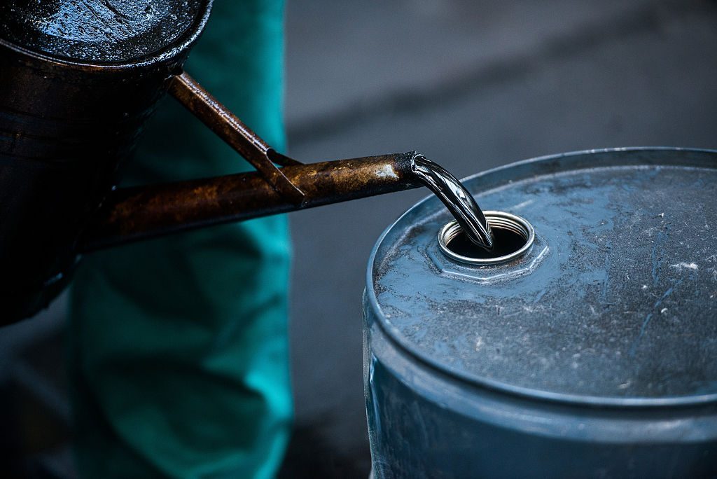 A worker pours liquid oil into a barrel at the delayed coker unit of the Duna oil refinery operated by MOL Hungarian Oil and Gas Plc in Szazhalombatta, Hungary.