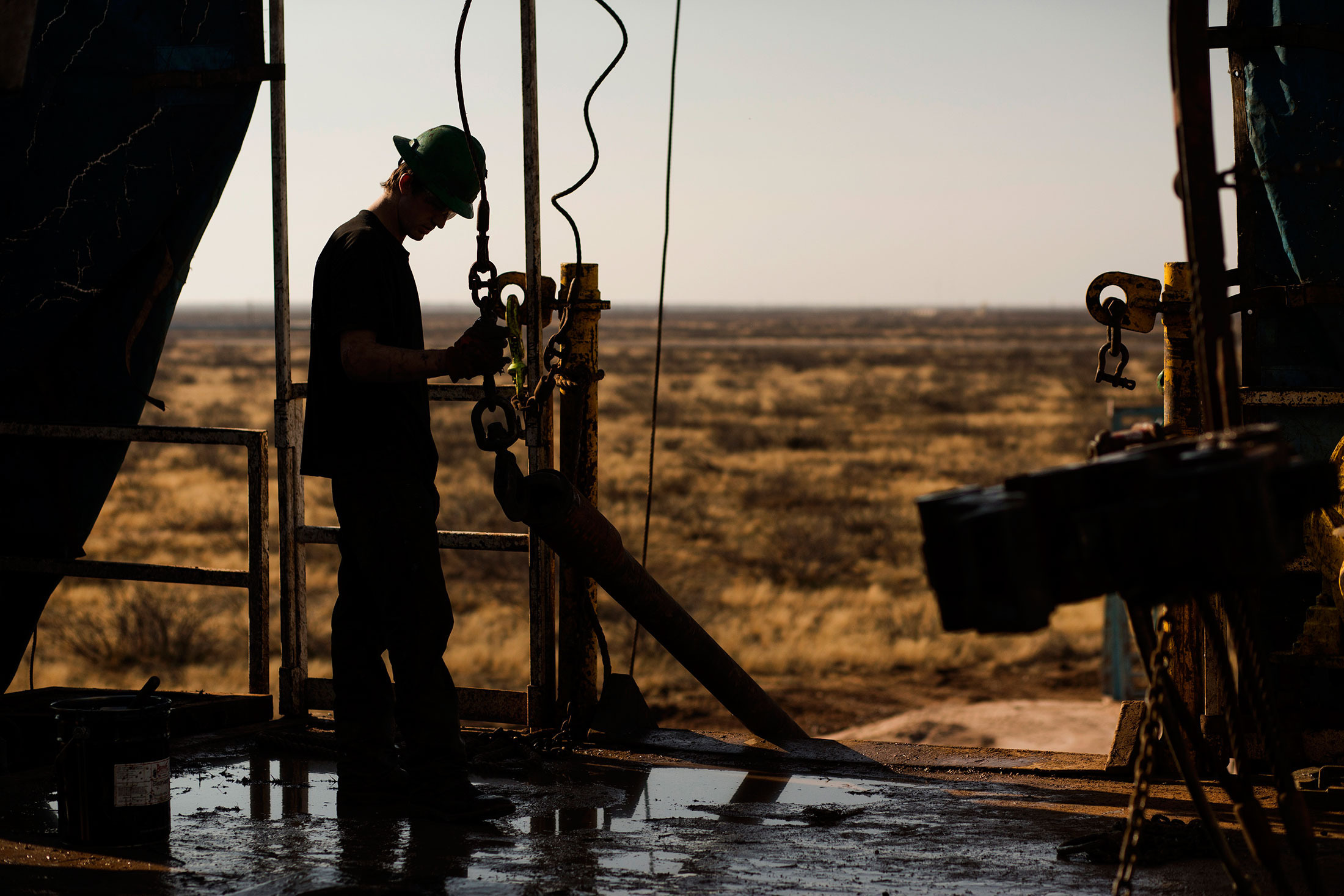 A worker waits to connect a drill bit on Endeavor Energy Resources LP's Big Dog Drilling Rig 22 in the Permian basin outside of Midland, Texas. Photographer: Brittany Sowacke/Bloomberg