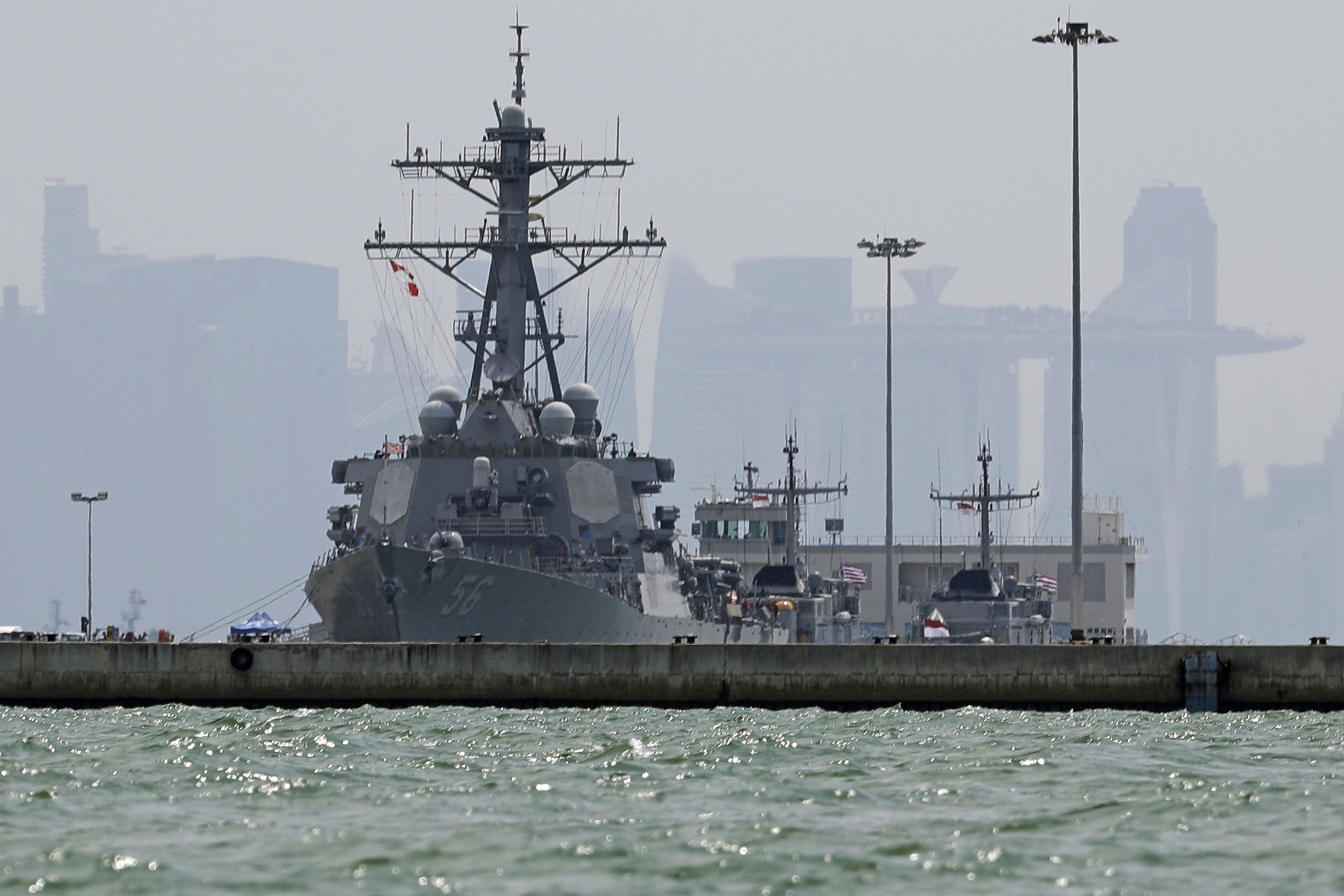 The USS John S. McCain is seen docked at Changi naval base after its accident on Monday, Aug. 21, 2017 in Singapore. The USS John S. McCain was docked at Singapore's naval base with "significant damage" to its hull (blocked by berth) after an early morning collision with the oil tanker Alnic MC as vessels from several nations searched Monday for missing U.S. sailors. (AP Photo/Wong Maye-E)