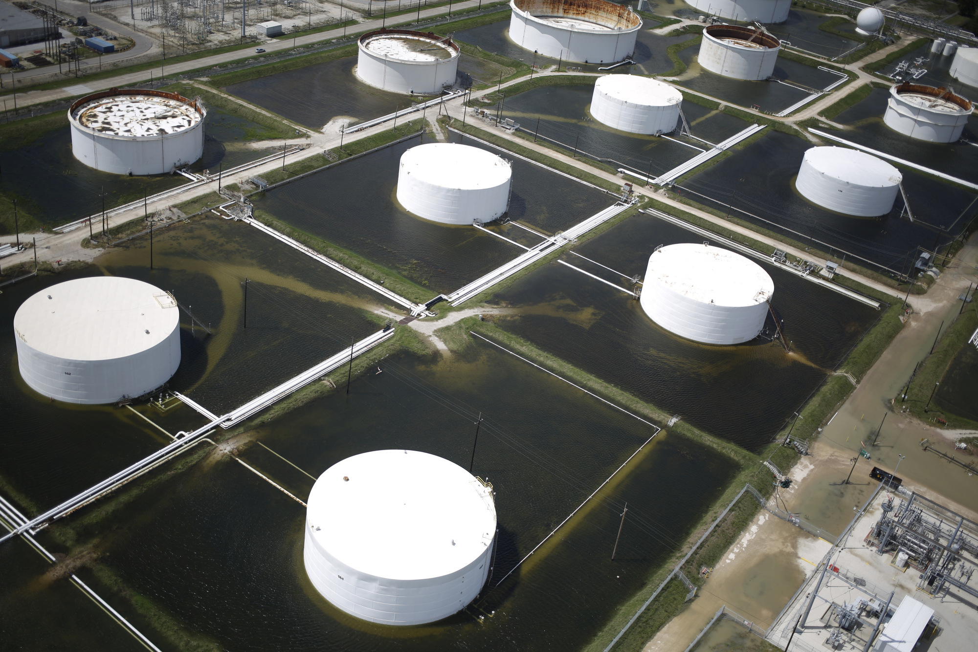 Rainwater from Hurricane Harvey surrounds oil refinery storage tanks in this aerial photograph taken above Texas City, Texas, U.S., on Wednesday, Aug. 30, 2017. Unprecedented flooding from the Category 4 storm that slammed into the state's coast last week, sending gasoline prices surging as oil refineries shut, may also set a record for rainfall in the contiguous U.S., the weather service said Tuesday. Photographer: Luke Sharrett/Bloomberg