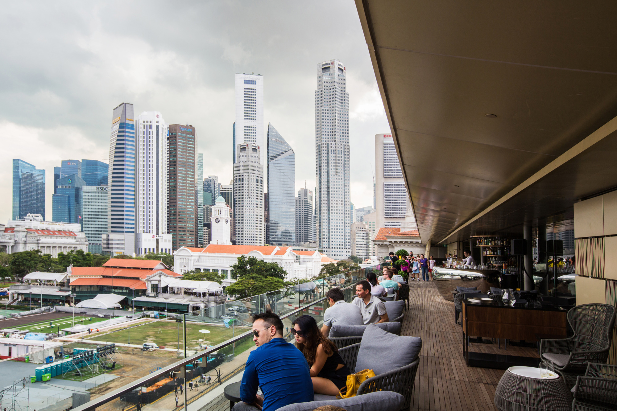 Visitors sit in a cafe at the National Gallery Singapore as commercial buildings stand in the background in Singapore, on Friday, Nov. 27, 2015. Photographer: Nicky Loh/Bloomberg