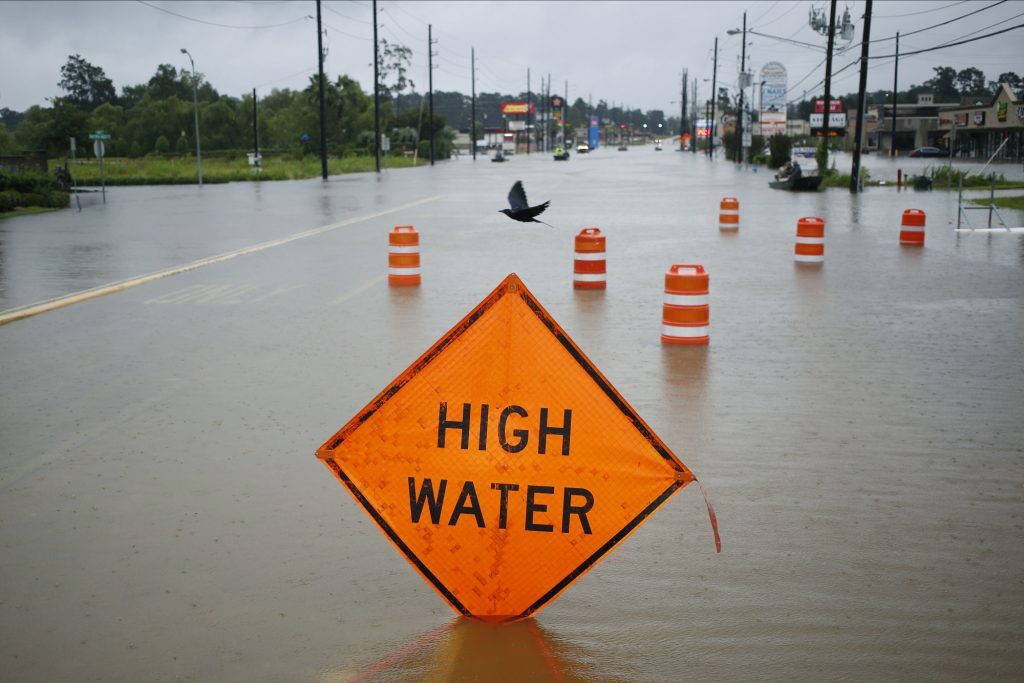 A "High Water" and orange traffic barrels stand in floodwaters from Hurricane Harvey in Spring, Texas, U.S. Photographer: Luke Sharrett/Bloomberg