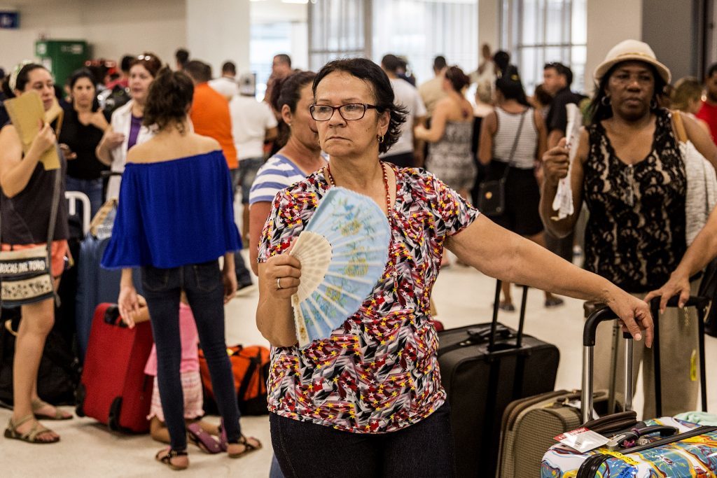 Travelers stand in line at Luis Muoz Marn International Airport in San Juan, Puerto Rico, on Monday, Sept. 25, 2017. Hurricane Maria hit the Caribbean island last week, knocking out electricity throughout the island. The territory is facing weeks, if not months, without service as utility workers repairpowerplants and lines that were already falling apart. Photographer: Alex Wroblewski/Bloomberg