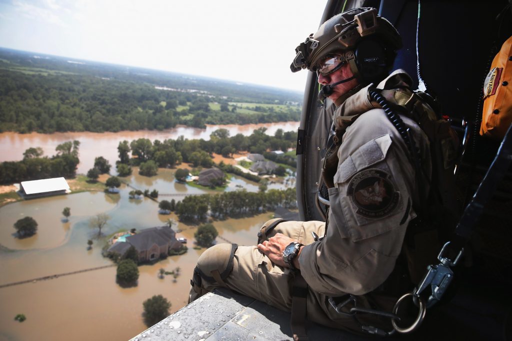 SUGAR LAND, TX - AUGUST 31:  Oscar Peru of  U.S. Customs and Border Protection searches for flood victims from a helicopter after torrential rains pounded the area following Hurricane and Tropical Storm Harvey on August 31, 2017 near Sugar Land, Texas. Harvey, which made landfall north of Corpus Christi August 25, has dumped nearly 50 inches of rain in and around areas Houston.  (Photo by Scott Olson/Getty Images)