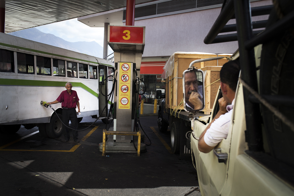 Customers refuel their vehicles at a Petroleos de Venzuela SA (PDVSA) gas station in Caracas, Venezuela on Feb. 11, 2016. President Nicolas Maduro, who has declared an "economic emergency," told lawmakers last month that it was time to raise gasoline prices in Venezuela where prices are the cheapest in the world. Photographer: Wilfredo Riera/Bloomberg