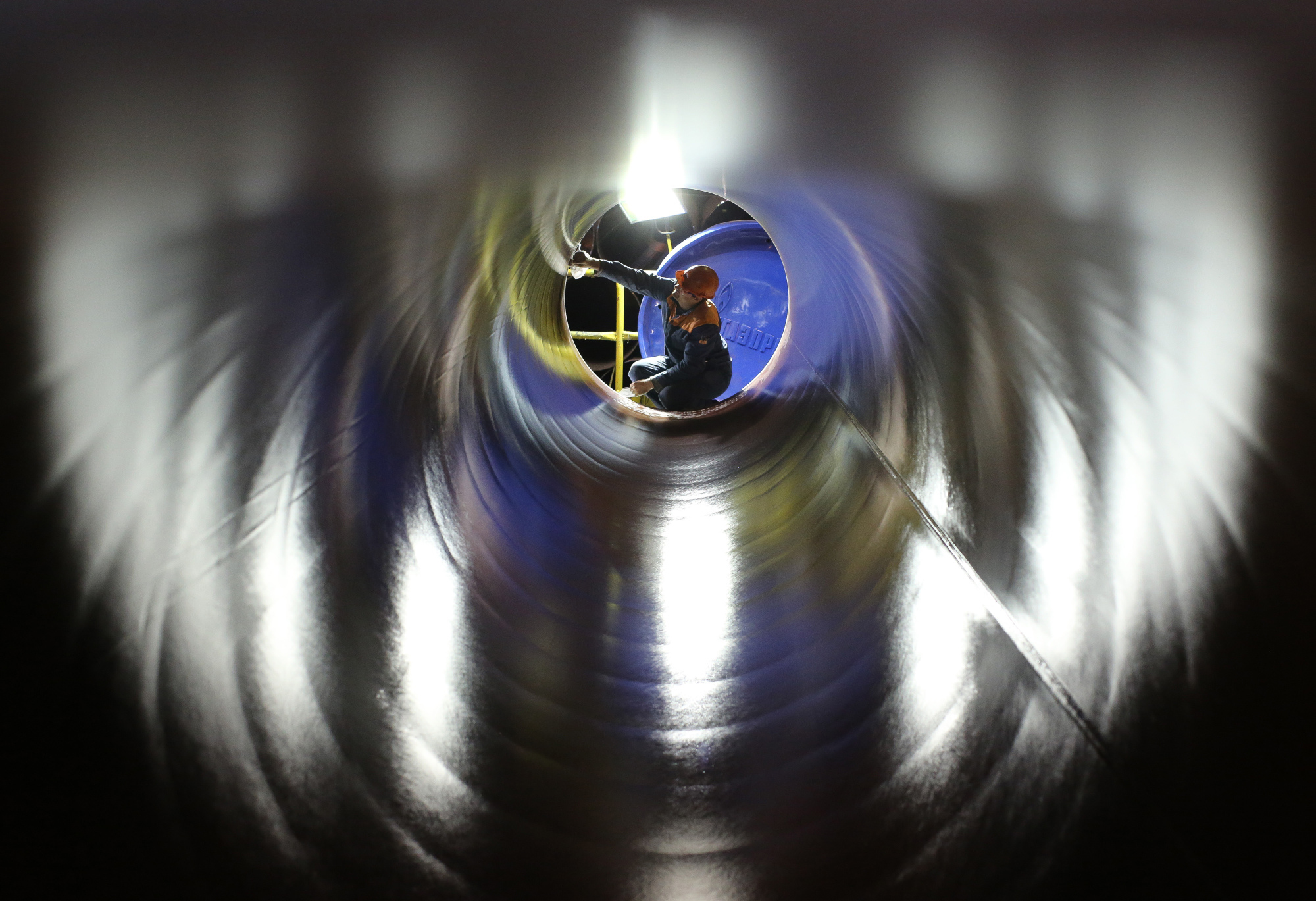 A worker checks the inside of a longitudinally welded large diameter steel pipe for use in oil and gas pipelines in a storage area at the Volzhsky Pipe Plant OJSC, operated by TMK PJSC, in Volzhsky, Russia, on March 30, 2017. Russian pipe producer TMK PJSC expects its U.S. business to recover as higher oil prices and President Donald Trumps trade and infrastructure policies boost demand. Photographer: Andrey Rudakov/Bloomberg